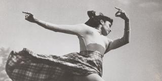 a woman dances through the air as her skirt trails behind her