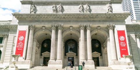 Exterior of the Stephen A. Schwarzman building with red banners displayed on the front.
